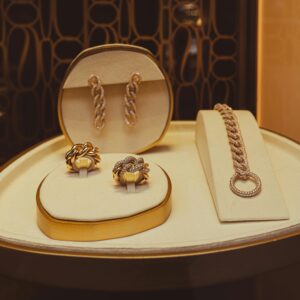 A refined display of elegant gold jewelry pieces in a store setting, showcasing earrings, rings, and a bracelet.